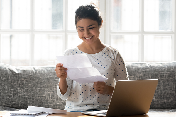 Smiling person reading a piece of paper